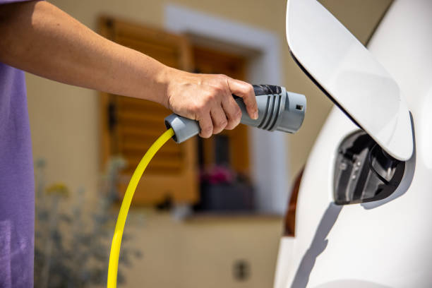 CV charger in Armadale Woman plugging in electric car charging plug at parking lot