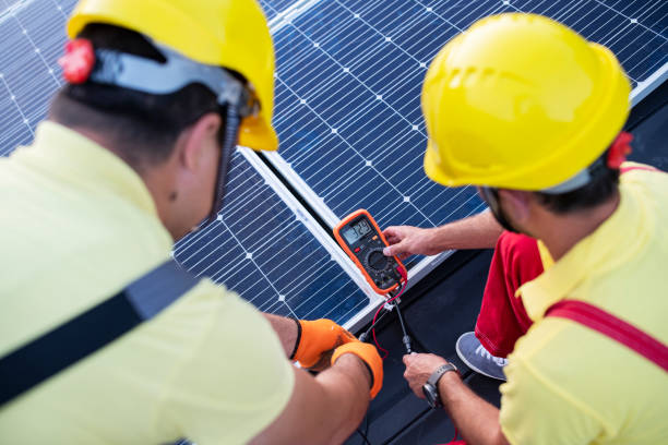 Power Engineers Mesuring Solar Energy On Panels On A Roof Of A House